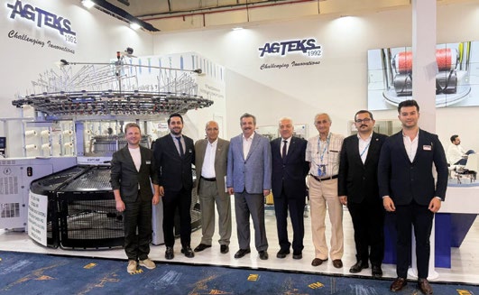 ITM 2026 fuarında AGTEKS standı, yuvarlak örme makinesi önünde firma yetkilileri ve ziyaretçiler
